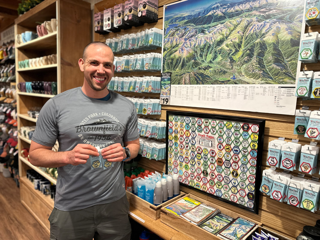 Image of a man holding two trail tags in Brownfield's Estes Park Colorado