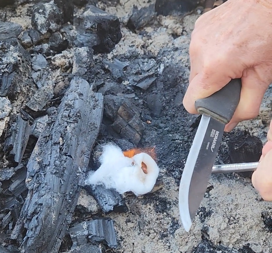 Practicing fire starting with ferro rod and cotton.